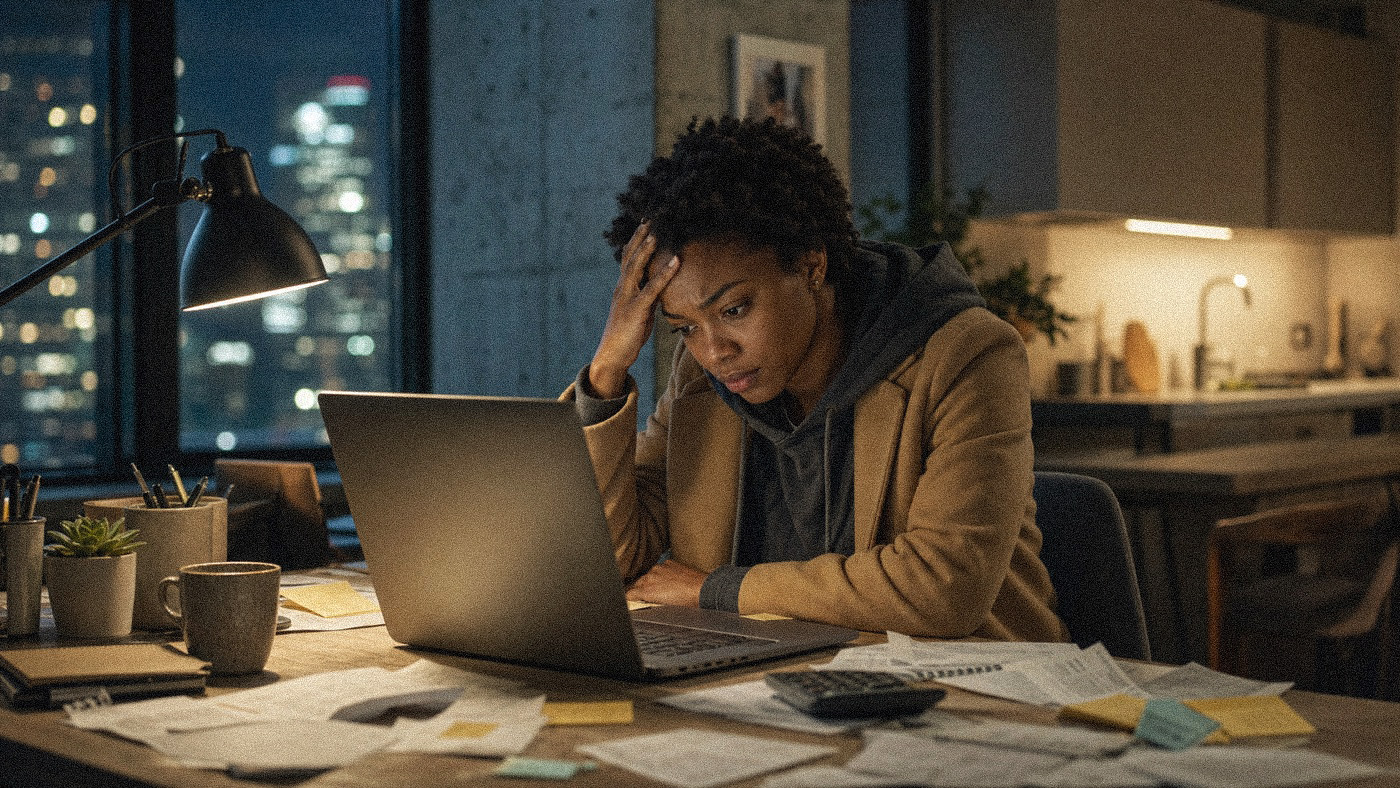 Hunched over a laptop and a desk full of paperwork late at night