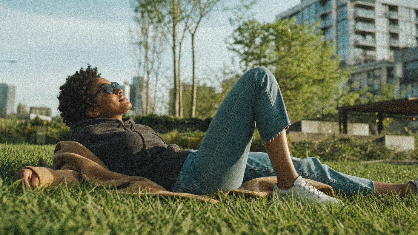 Lying back on the grass in a city park on a sunny afternoon